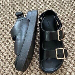 Black platform double strap sandals with gold buckles